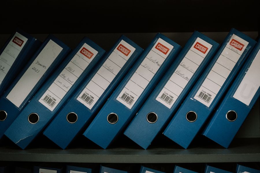 Neatly organised office binders on a shelf